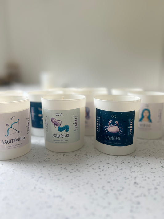 Star sign candles in matte white vessels featuring Sagittarius, Aquarius, and Cancer designs with a French vanilla scent.